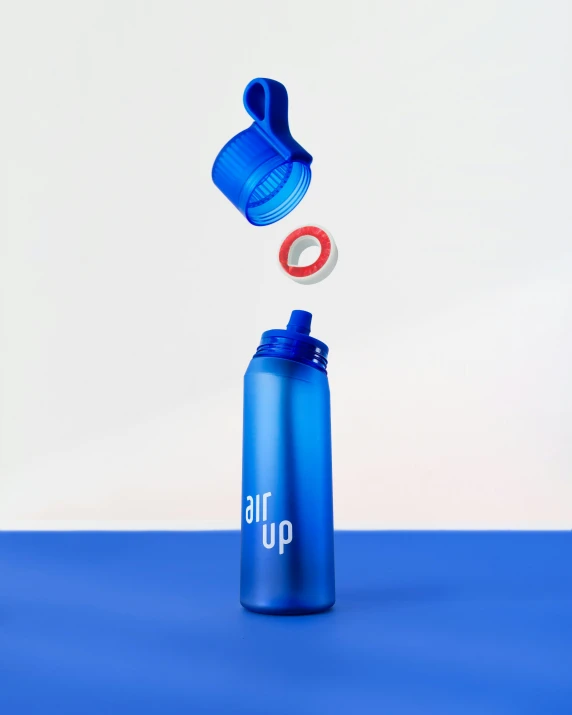 a blue bottle on the ground with a toothbrush sticking out