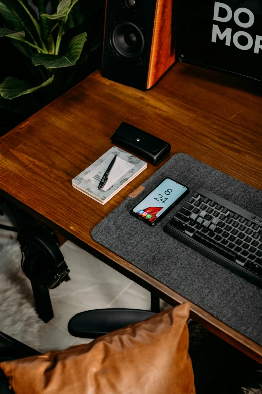 a wooden desk with a keyboard a mouse and phone on it