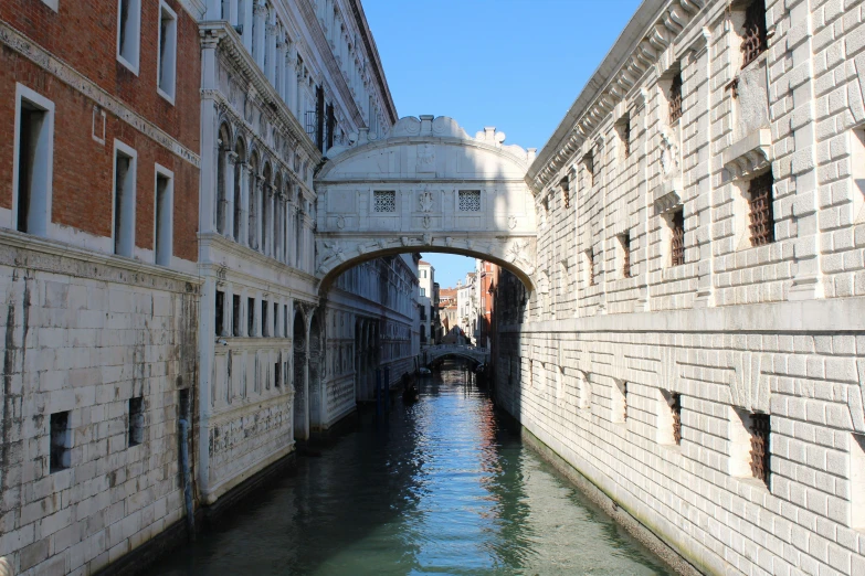 an arched bridge and narrow buildings make up this canal