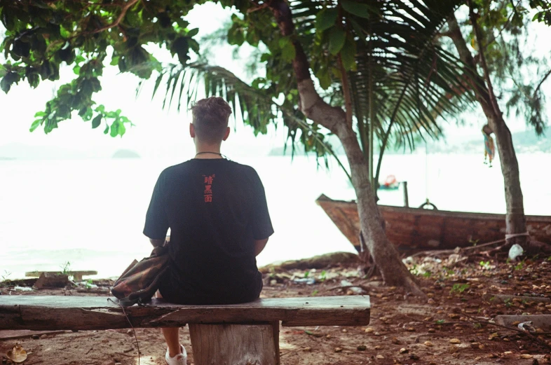 a man sitting on a bench near a lake