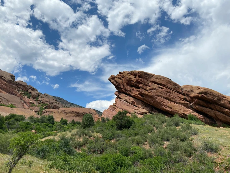 the landscape with rocks on it has green bushes and trees in it