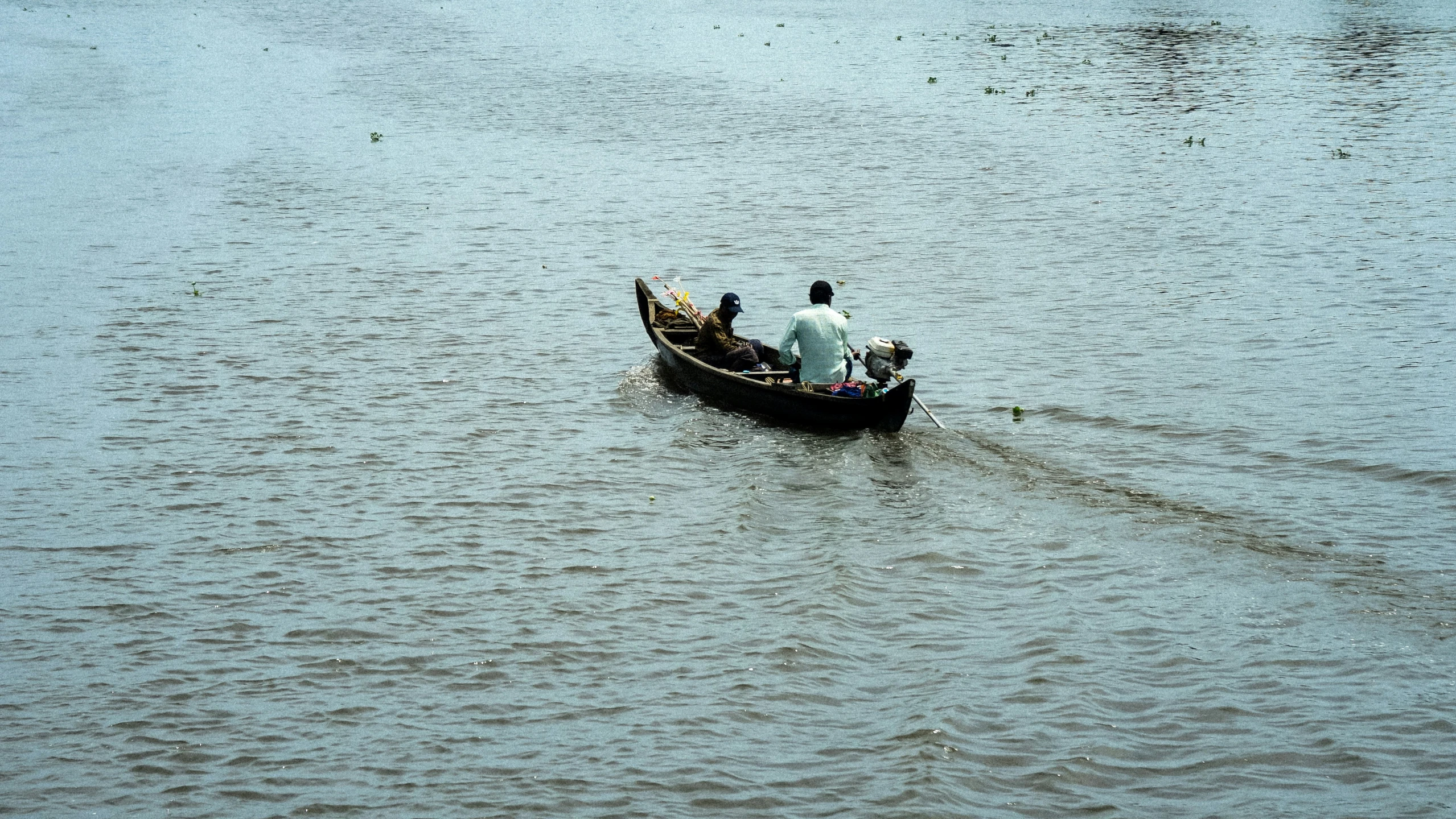 two people in a small boat with a person on it