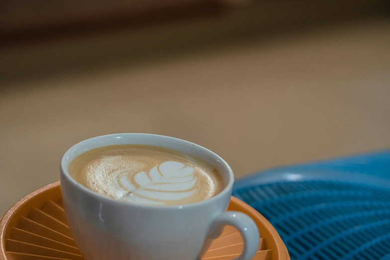 a cup of coffee on top of an orange tray