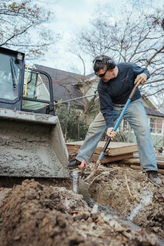 a man digging in the dirt with a shovel and a tractor