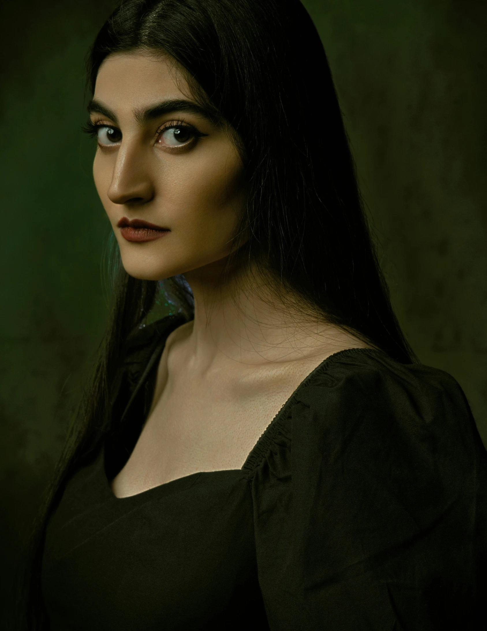 a woman posing for a portrait wearing a black shirt
