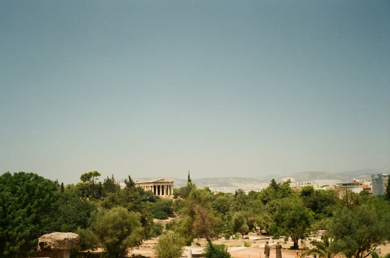 trees and a building on the outskirts of an ancient city