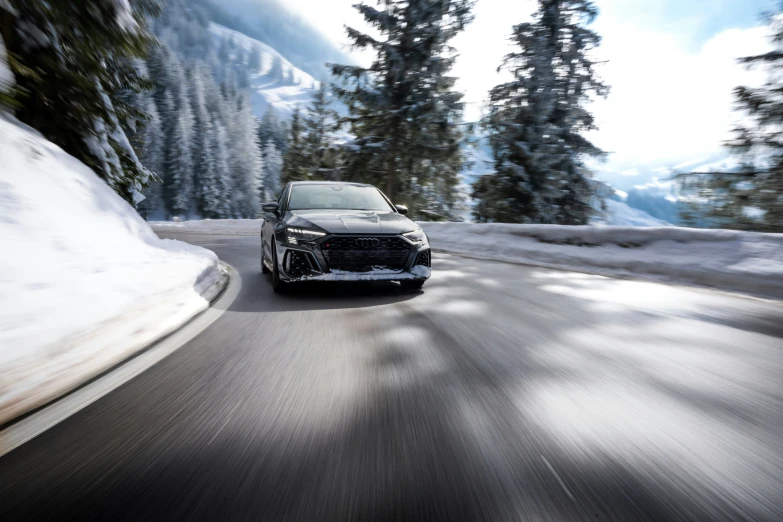 a black and white car driving down a mountain side