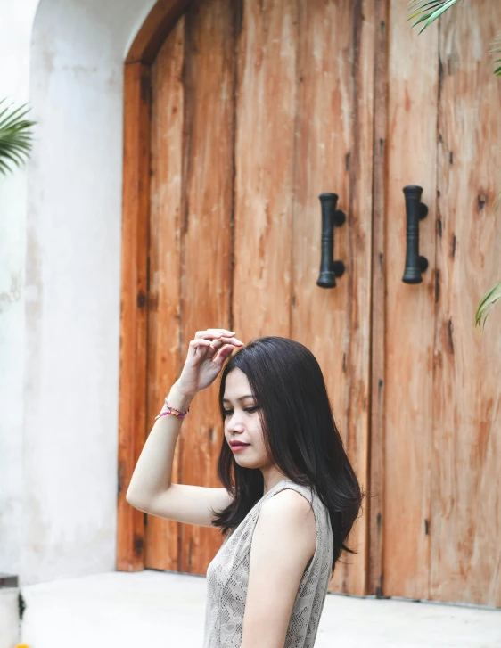 woman in dress standing by the door of a building