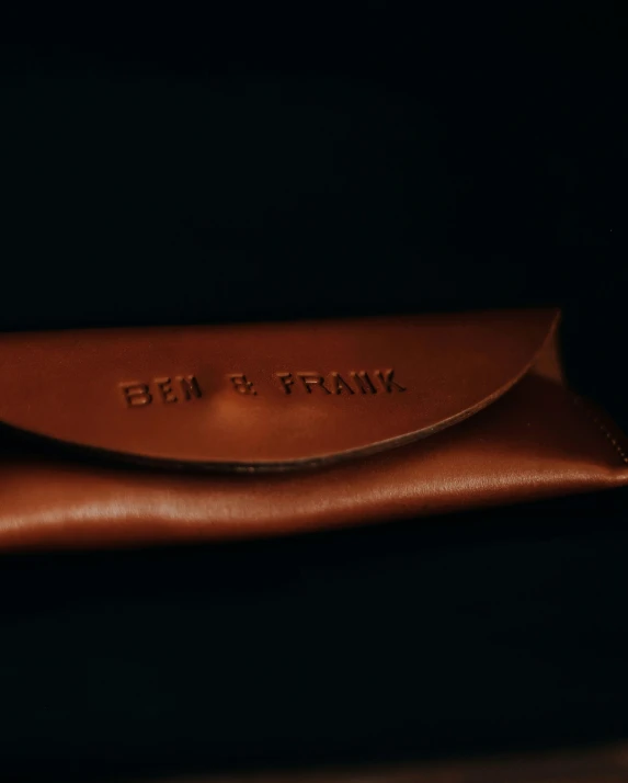 brown sunglasses case with the word ben and frank on it