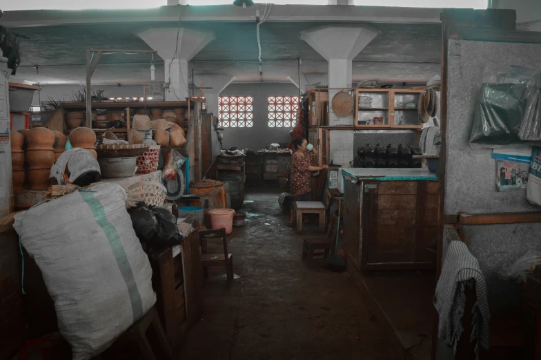 some pots in a room with many bottles on the walls