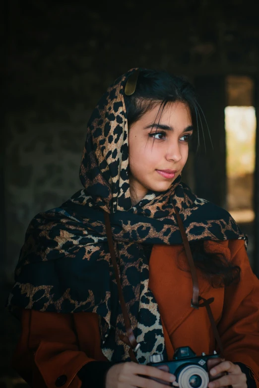 a young woman with a scarf is posing for the camera