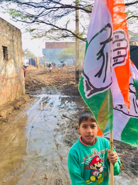 there is a  holding an indian flag in the mud