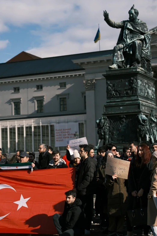 many people are standing by a big statue