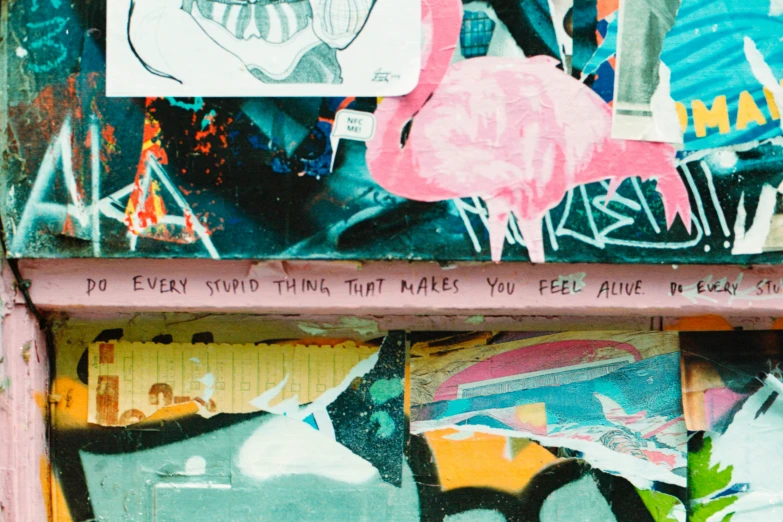 wall with pink flamingo and other graffiti all over it