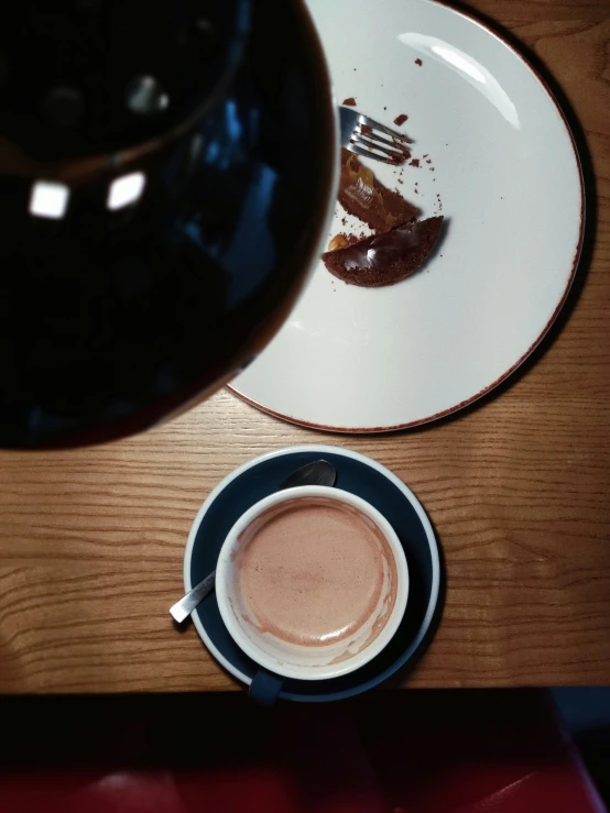 a table topped with a plate and coffee cup
