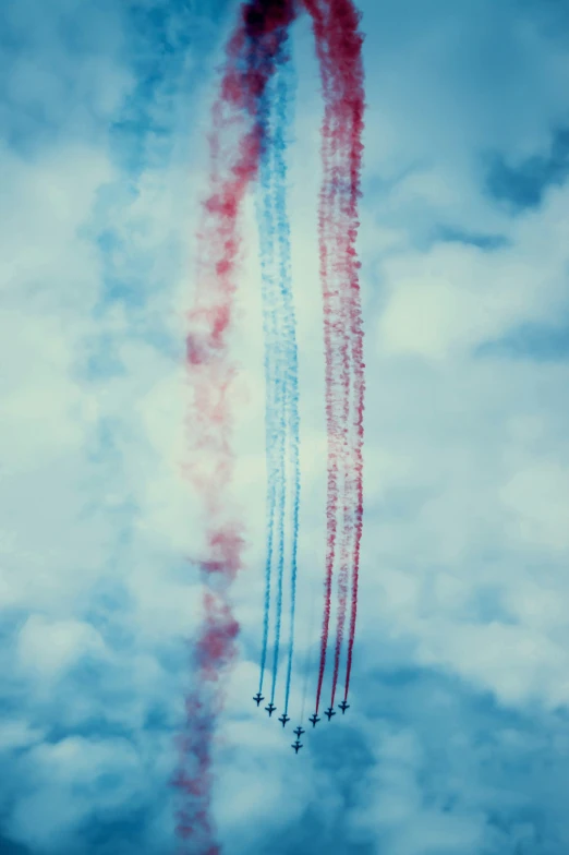 planes are flying in formation and trailing colored smoke