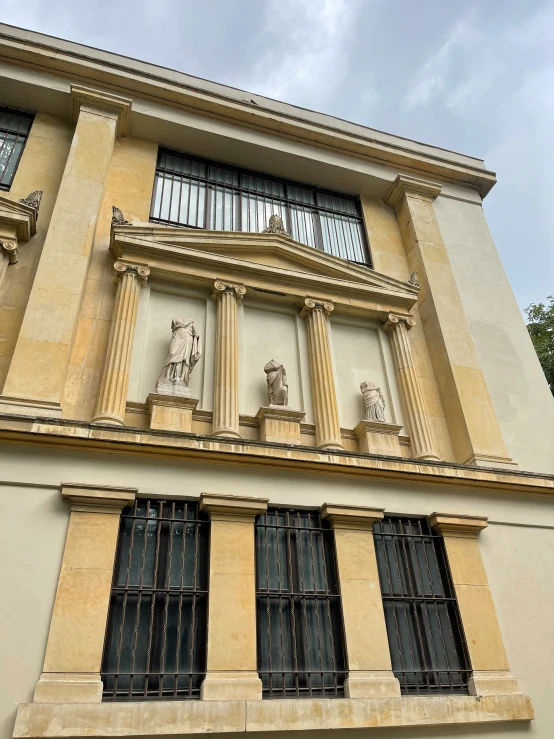 an old building with several windows has sculptures on the side