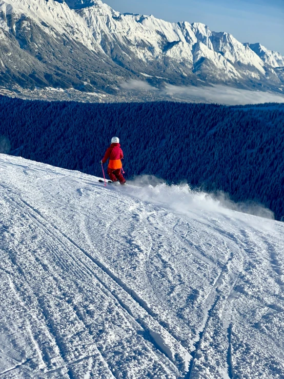 skier at the top of a mountain slope in a colorful coat