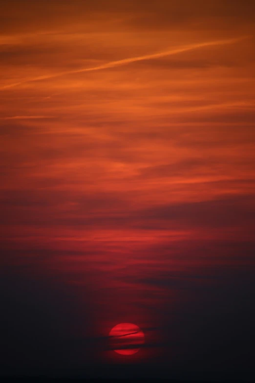 a plane is flying against an orange sky