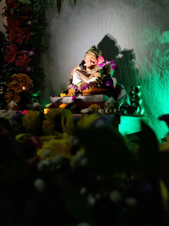 a man sitting on the floor next to some fake flowers