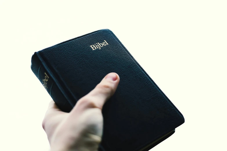 a person pointing their hand at a small black notebook