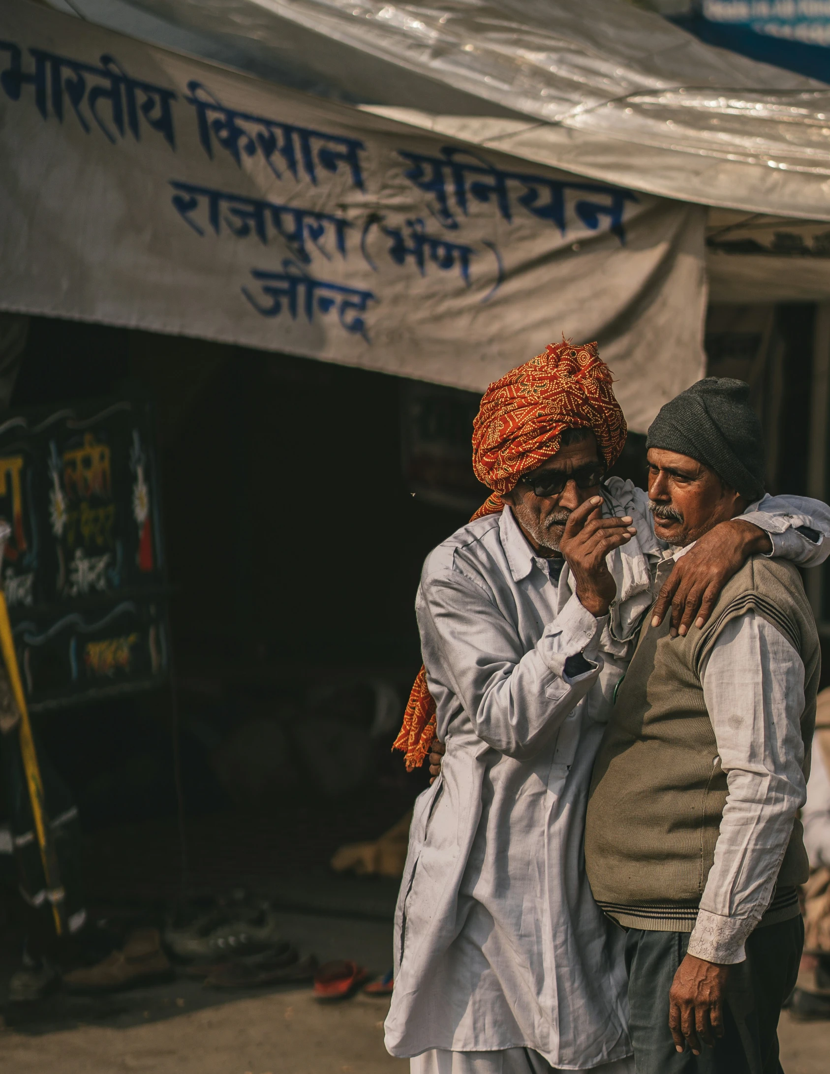 a couple of men standing next to each other on the street