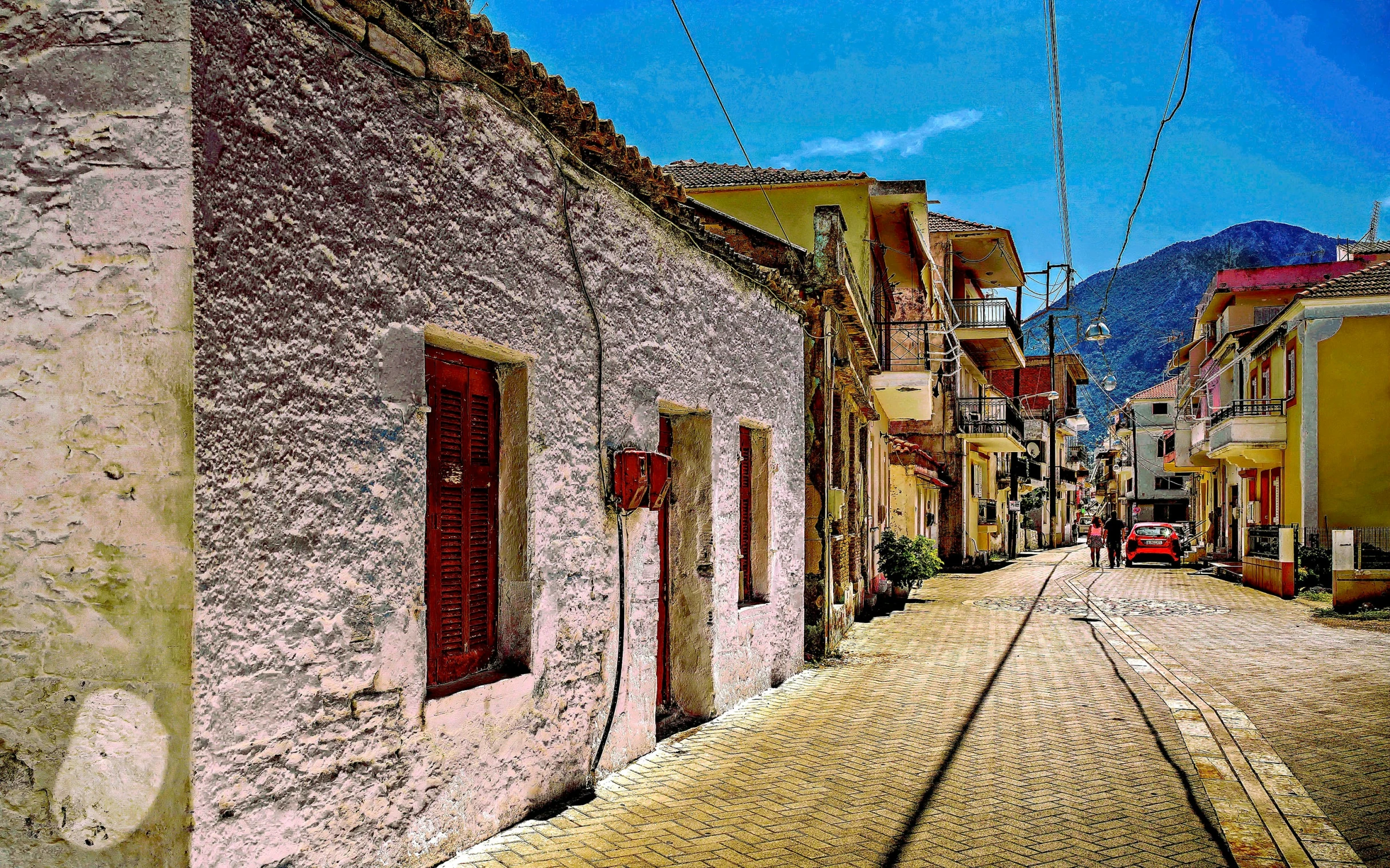 a long view of the city street from behind an old brick building