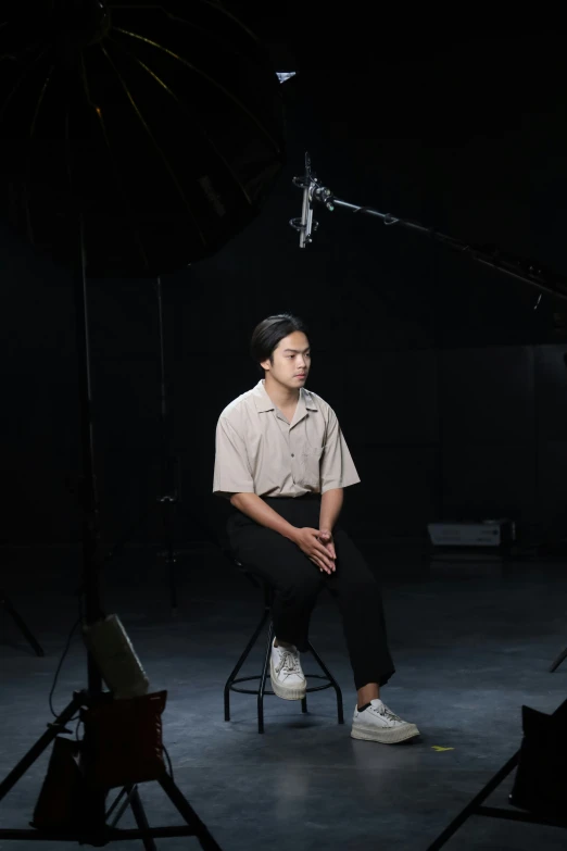 a man is sitting down in a po studio