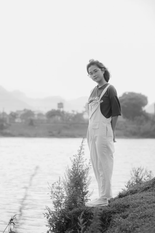 a woman is standing in front of a body of water