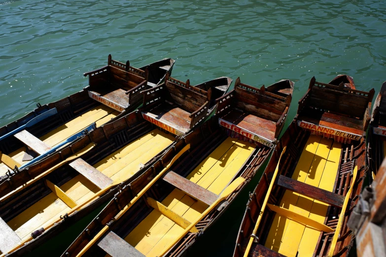 some long and small boats sit on the water