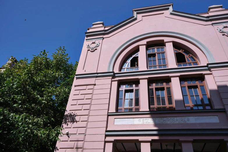 an image of a pink building with windows and doors