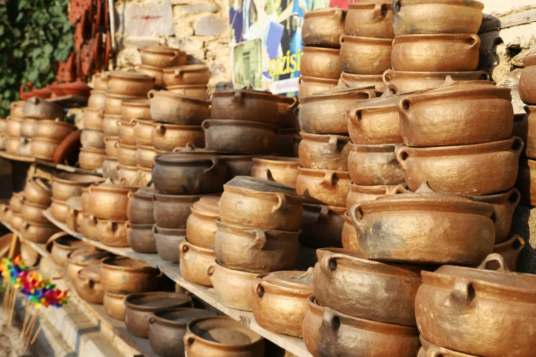 several pots are on a rack against a wall