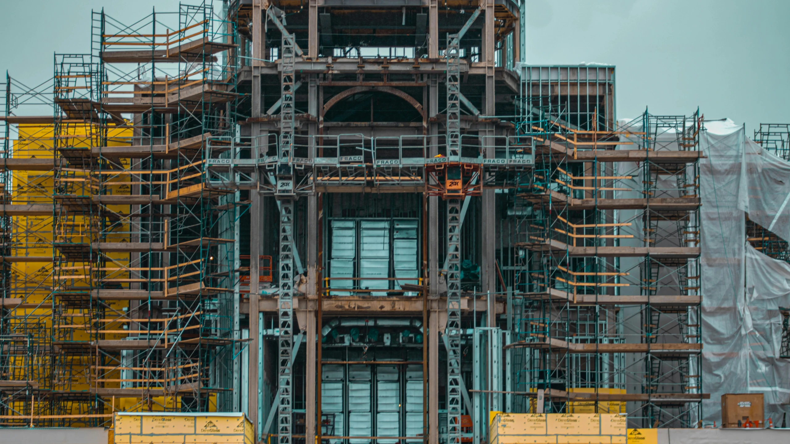 a large metal structure with yellow scaffoldings and fire hydrants