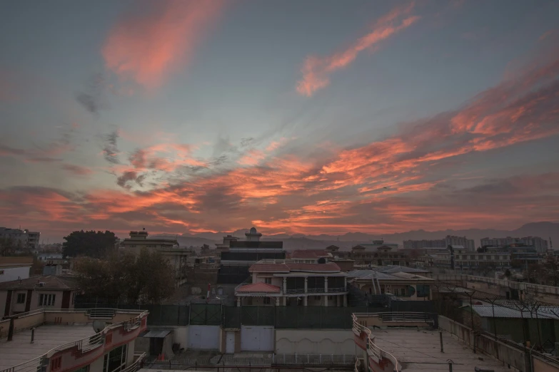 a red sky with some white clouds over a city