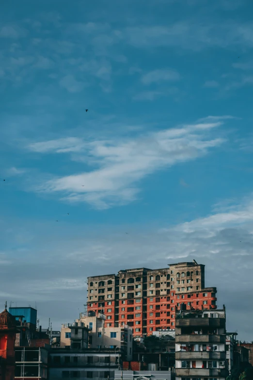 buildings under the clouds and a bird flying in the sky