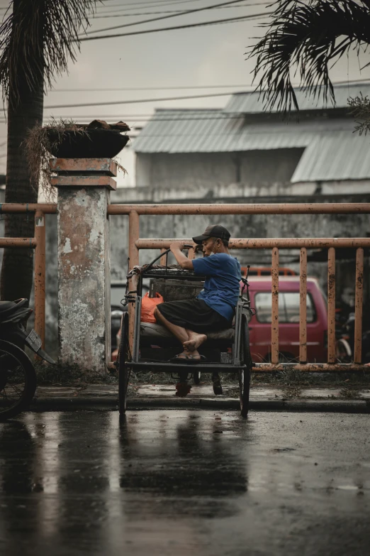 the woman is sitting outside alone in the rain