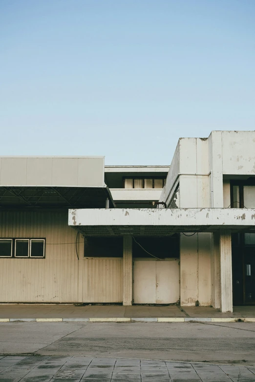 a parking lot with two empty garages and two windows