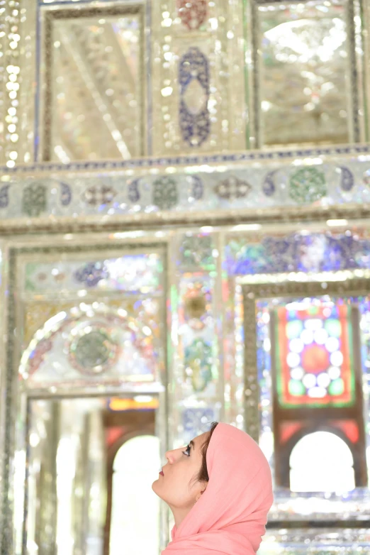 a woman wearing a head scarf in front of an oriental style temple