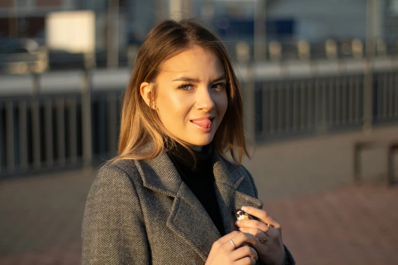 a beautiful woman wearing a suit standing next to a street