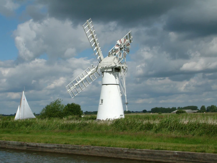 an old windmill sitting next to a body of water