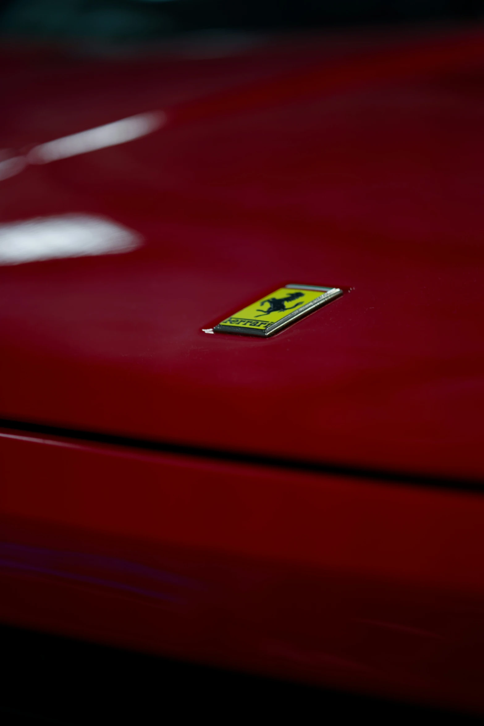 the bumper of a red car with a yellow sticker on it