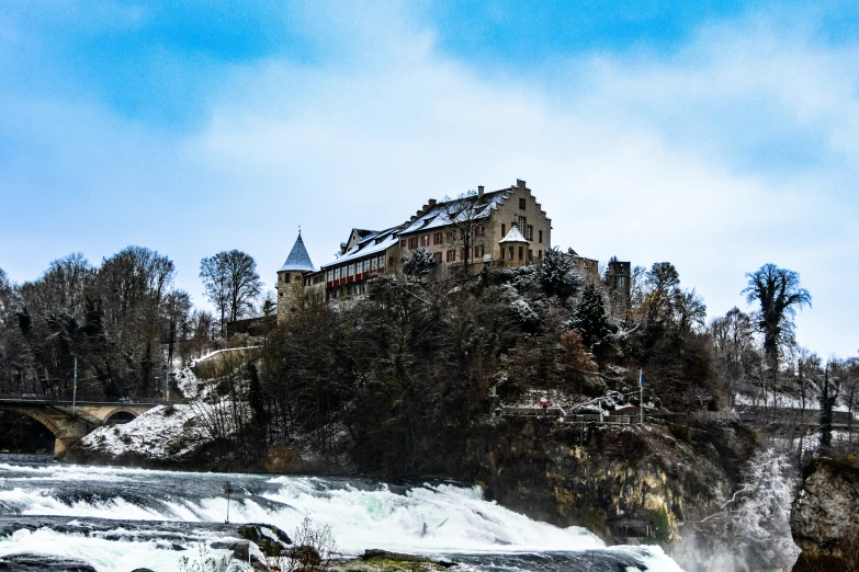 a building sits in the snow over a river