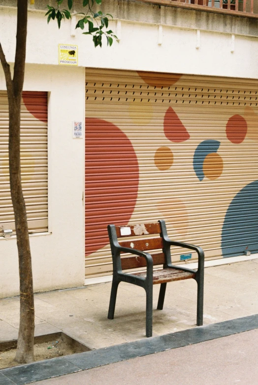 an empty bench outside a closed garage