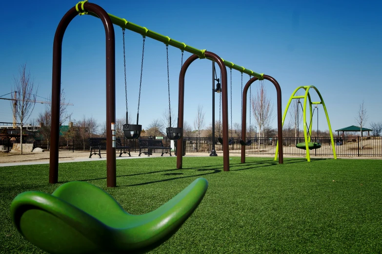 an empty park with many swings and chairs