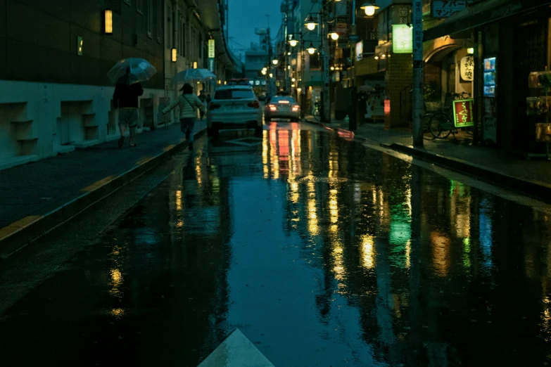 a wet street that has some cars parked in it