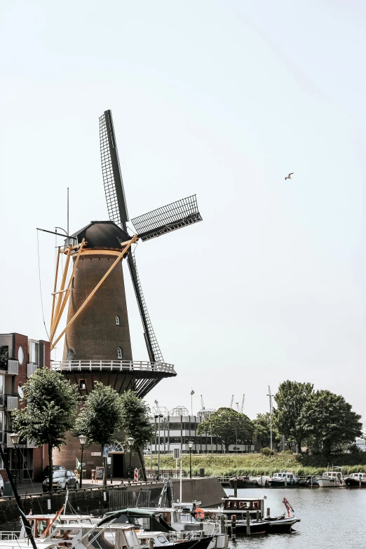 a mill stands in the water next to a dock