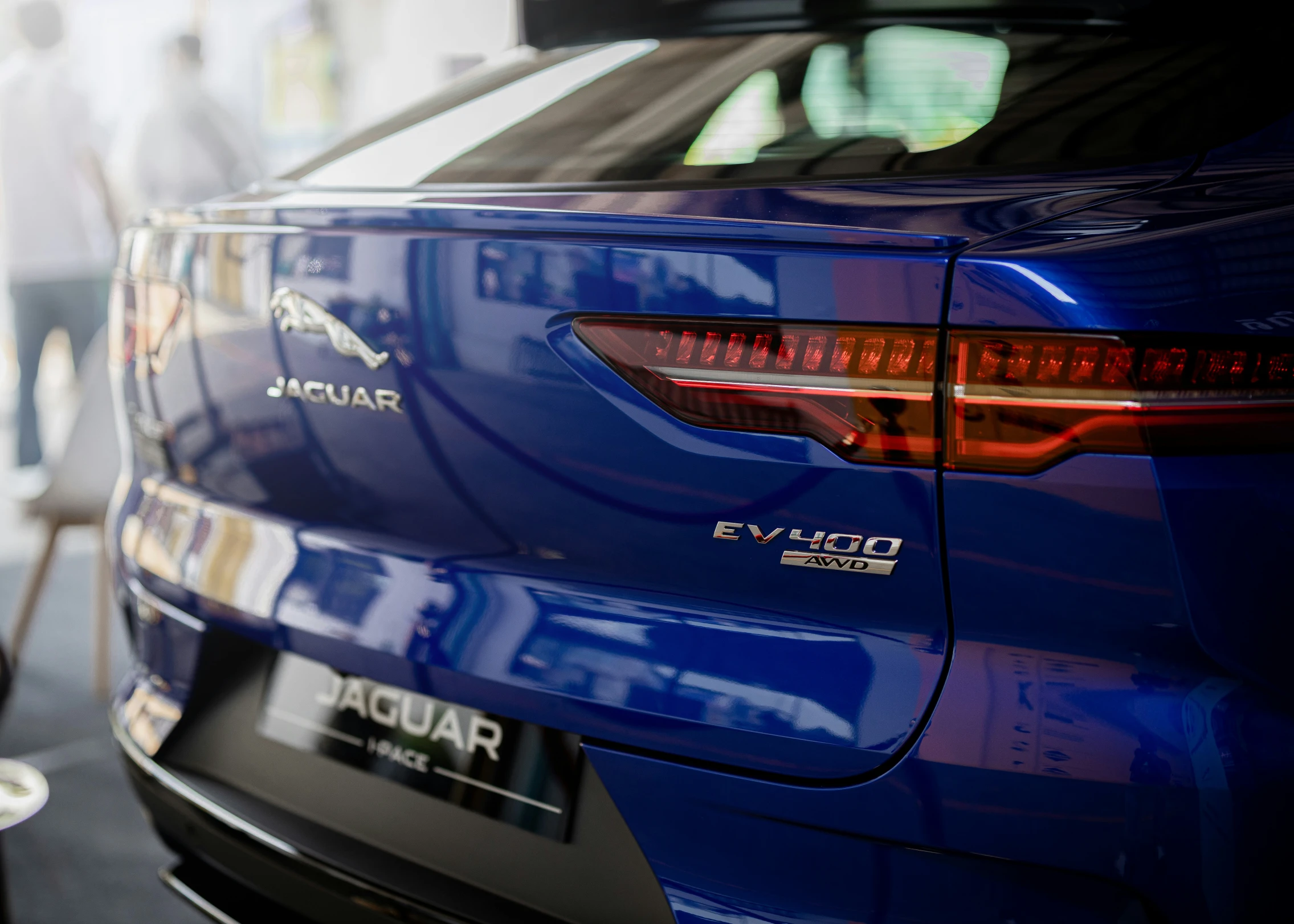 a close up view of the tail light and emblem of a blue sedan