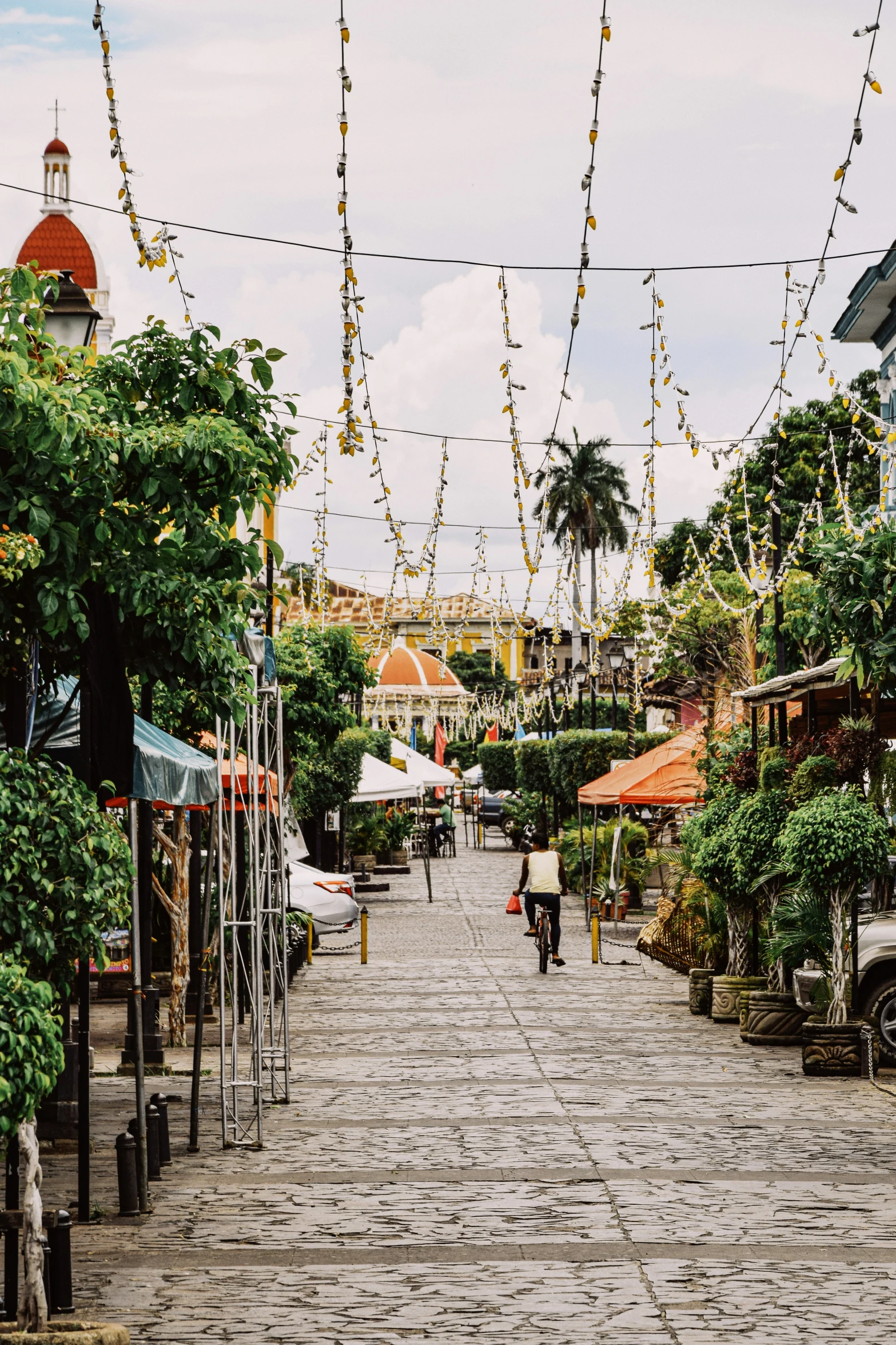 a brick walkway lined with lots of lights and decorations