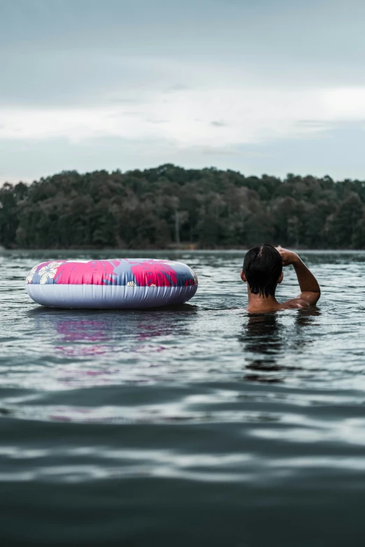 a man laying in the water with his surfboard on top