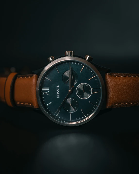 the watch is on a leather strap with a black face